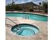 Features a in-ground hot tub with a tile surround, accompanied by a view of the pool area and desert landscape beyond at 1725 E Staghorn Ln, Carefree, AZ 85377