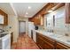 Traditional kitchen with wooden cabinets, double basin sink, white appliances, and terracotta tiled flooring at 1725 E Staghorn Ln, Carefree, AZ 85377