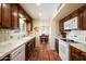 Traditional kitchen featuring wood cabinets, white appliances, a double basin sink, and terracotta tiled flooring at 1725 E Staghorn Ln, Carefree, AZ 85377