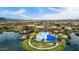 Panoramic aerial view of a vibrant community featuring a lake, pools, and manicured green spaces at 18076 W Redwood Ln, Goodyear, AZ 85338