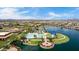 Aerial view of a resort-style community with a pool, lake, and stunning mountain views at 18076 W Redwood Ln, Goodyear, AZ 85338