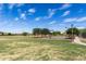 Community basketball court surrounded by green space and mature trees, providing a recreational area for sports enthusiasts at 18076 W Redwood Ln, Goodyear, AZ 85338