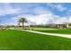 Scenic community green space featuring lush lawns, palm trees, and a relaxing covered picnic area at 18076 W Redwood Ln, Goodyear, AZ 85338