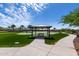 Scenic community area featuring lush green grass, covered picnic area, and picturesque landscaping, perfect for outdoor enjoyment at 18076 W Redwood Ln, Goodyear, AZ 85338