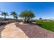 Scenic community spot with a stone walkway, landscaped area, mature trees, and a charming seating area for relaxation at 18076 W Redwood Ln, Goodyear, AZ 85338