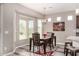 A dining area featuring a dark wood table set, enhanced by natural light from a large window at 18076 W Redwood Ln, Goodyear, AZ 85338