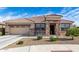 Charming single-story home with a tile roof and a stone-accented entrance, showcasing curb appeal at 18076 W Redwood Ln, Goodyear, AZ 85338