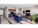 Bright and airy living space with hardwood floors, media center, and a cozy blue chair at 18076 W Redwood Ln, Goodyear, AZ 85338