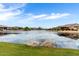 Scenic community pond with grassy area, and views of nearby homes at 18076 W Redwood Ln, Goodyear, AZ 85338