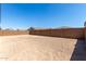 Unlandscaped backyard features a block wall with a view of neighboring rooftops at 18189 W Hess St, Goodyear, AZ 85338