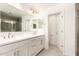 Modern bathroom with double vanity, large mirror, and tiled shower with glass doors at 18189 W Hess St, Goodyear, AZ 85338
