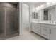 Bathroom featuring double sinks with modern fixtures and tiled walk-in shower at 18189 W Hess St, Goodyear, AZ 85338