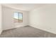 A bright bedroom features a large window and plush gray carpeting at 18189 W Hess St, Goodyear, AZ 85338