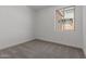 Bedroom featuring neutral carpet, baseboard trim and a window at 18189 W Hess St, Goodyear, AZ 85338