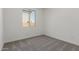 Bedroom featuring neutral carpet, baseboard trim and a window at 18189 W Hess St, Goodyear, AZ 85338