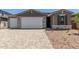 Charming single-story home with a three-car garage, stone accents, and desert landscaping at 18189 W Hess St, Goodyear, AZ 85338