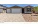 Charming single-story home featuring a three-car garage, stone accents, and a beautifully landscaped front yard at 18189 W Hess St, Goodyear, AZ 85338