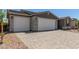 Spacious three-car garage with stone detailing and a large paver driveway at 18189 W Hess St, Goodyear, AZ 85338