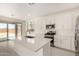 Kitchen with island, stainless appliances, white shaker cabinets, quartz countertops, and slider to covered patio at 18189 W Hess St, Goodyear, AZ 85338