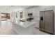 Bright kitchen with stainless steel appliances, white cabinets, an island with a sink, and backyard views at 18189 W Hess St, Goodyear, AZ 85338