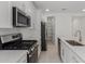 Open kitchen featuring stainless steel appliances, white cabinets, pantry and an island with a sink at 18189 W Hess St, Goodyear, AZ 85338