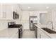 The kitchen features stainless steel appliances, white cabinets, quartz countertops and subway tile backsplash at 18189 W Hess St, Goodyear, AZ 85338
