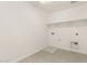 A bright laundry room features a large shelf and gray tile flooring at 18189 W Hess St, Goodyear, AZ 85338