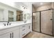 Modern bathroom features a double sink vanity, a walk-in shower with glass doors, and tiled flooring at 18195 W Hess St, Goodyear, AZ 85338