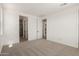 Large bedroom with views of the bath and kitchen, featuring plush carpeting and neutral colors at 18195 W Hess St, Goodyear, AZ 85338