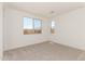 Bright and airy bedroom featuring two large windows and plush carpeting at 18195 W Hess St, Goodyear, AZ 85338