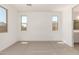 Spacious bedroom with plenty of natural light from two large windows and plush carpeting at 18195 W Hess St, Goodyear, AZ 85338