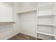 Walk-in closet features carpeted flooring, wooden racks and shelving with white shelving at 18195 W Hess St, Goodyear, AZ 85338