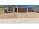 Charming single-Gathering home featuring a three-car garage, stone accents, and low-maintenance landscaping at 18195 W Hess St, Goodyear, AZ 85338