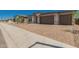 Beautiful home featuring desert landscaping, stone accents, and a brick paver driveway leading to a 2-car garage at 18195 W Hess St, Goodyear, AZ 85338