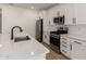 Bright kitchen featuring white cabinets, stainless steel appliances, and a subway tile backsplash at 18195 W Hess St, Goodyear, AZ 85338