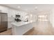 Spacious open-concept kitchen featuring white cabinets, stainless steel appliances, and a large island at 18195 W Hess St, Goodyear, AZ 85338