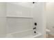 Close-up of a white tiled shower with a black showerhead and faucet at 18195 W Hess St, Goodyear, AZ 85338