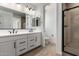 Modern bathroom featuring double vanity and glass enclosed tiled shower at 18204 W Hess St, Goodyear, AZ 85338