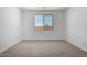 A bright bedroom featuring neutral carpet and natural light from a window at 18204 W Hess St, Goodyear, AZ 85338