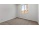 Bright bedroom featuring neutral carpet, a single window, and white walls at 18204 W Hess St, Goodyear, AZ 85338