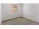 A bright bedroom features neutral carpet and a view from the window at 18204 W Hess St, Goodyear, AZ 85338