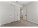 A light bedroom with neutral carpet and doors leading to closet and bathroom at 18204 W Hess St, Goodyear, AZ 85338
