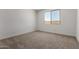 A bright bedroom features neutral carpet and a view from the window at 18204 W Hess St, Goodyear, AZ 85338