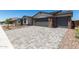 Beautiful paved driveway leading to a two car garage with stone accents and desert landscaping at 18204 W Hess St, Goodyear, AZ 85338
