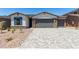 Charming single-story home featuring a brick-accented facade, well-manicured landscaping, and a spacious three-car garage at 18204 W Hess St, Goodyear, AZ 85338