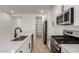 Open kitchen showcases stainless steel appliances, white cabinets, modern fixtures, and a convenient pantry at 18204 W Hess St, Goodyear, AZ 85338