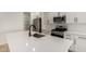 Modern kitchen featuring stainless steel appliances, sleek white cabinetry, and a spacious center island with a sink at 18204 W Hess St, Goodyear, AZ 85338