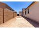 Side yard with dirt and block wall providing privacy between homes at 18204 W Hess St, Goodyear, AZ 85338