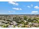 Expansive aerial view of a well-maintained neighborhood under a blue sky with scattered clouds at 19820 E Reins Rd, Queen Creek, AZ 85142