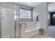 Bathroom boasts shower, soaking tub, towel racks and a glass block window for natural light at 19820 E Reins Rd, Queen Creek, AZ 85142